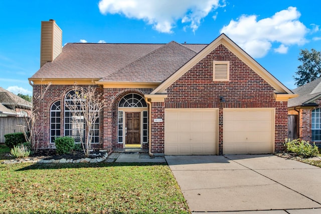 view of front facade featuring driveway, a front yard, a garage, and brick siding