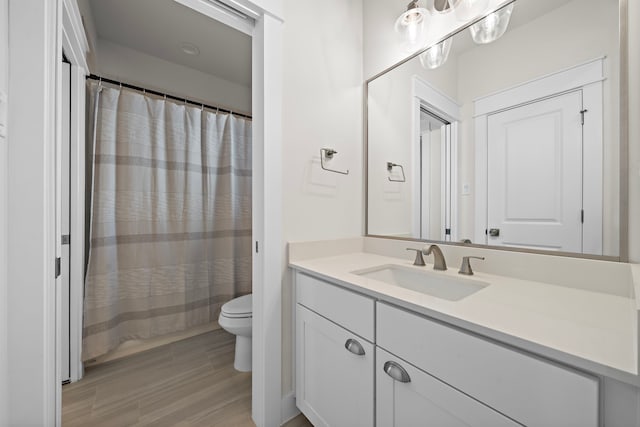 bathroom featuring wood-type flooring, vanity, and toilet