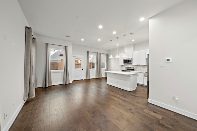 kitchen with a kitchen island, dark hardwood / wood-style floors, decorative light fixtures, white cabinets, and appliances with stainless steel finishes