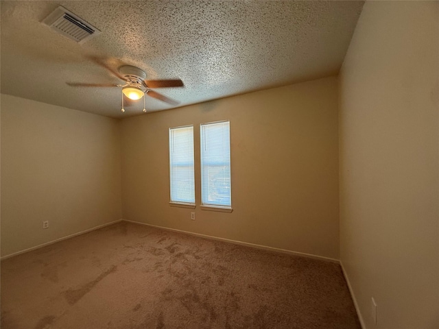 carpeted empty room with a textured ceiling and ceiling fan