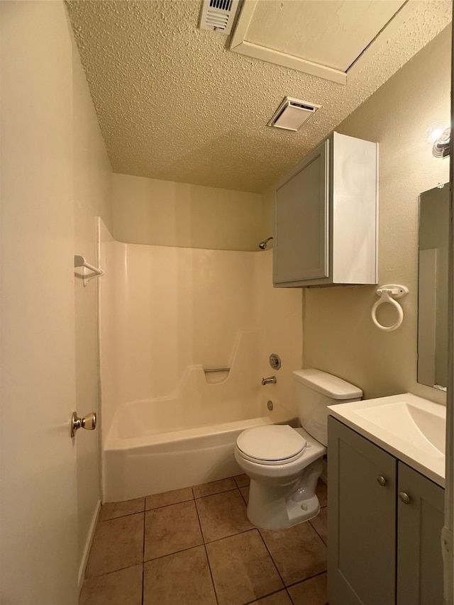 full bathroom featuring washtub / shower combination, tile patterned floors, a textured ceiling, toilet, and vanity