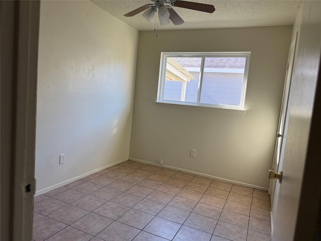 spare room with ceiling fan, light tile patterned floors, and a textured ceiling