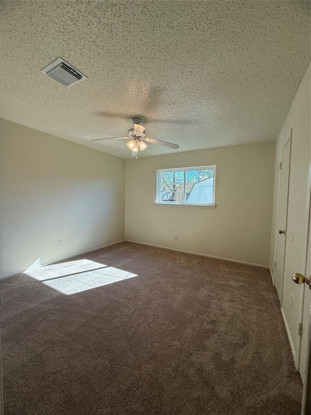 unfurnished room featuring ceiling fan, a textured ceiling, and dark colored carpet