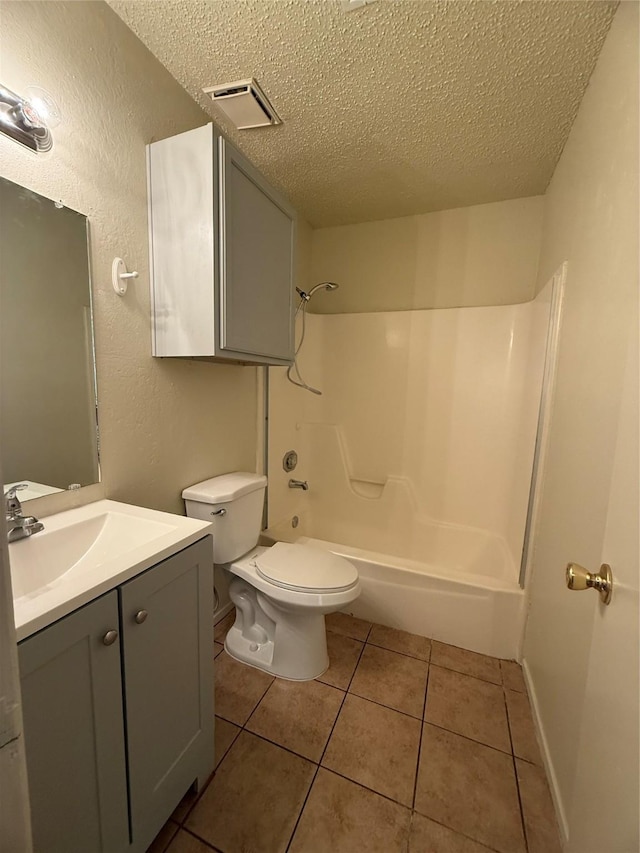 full bathroom featuring tile patterned flooring, toilet, washtub / shower combination, and a textured ceiling