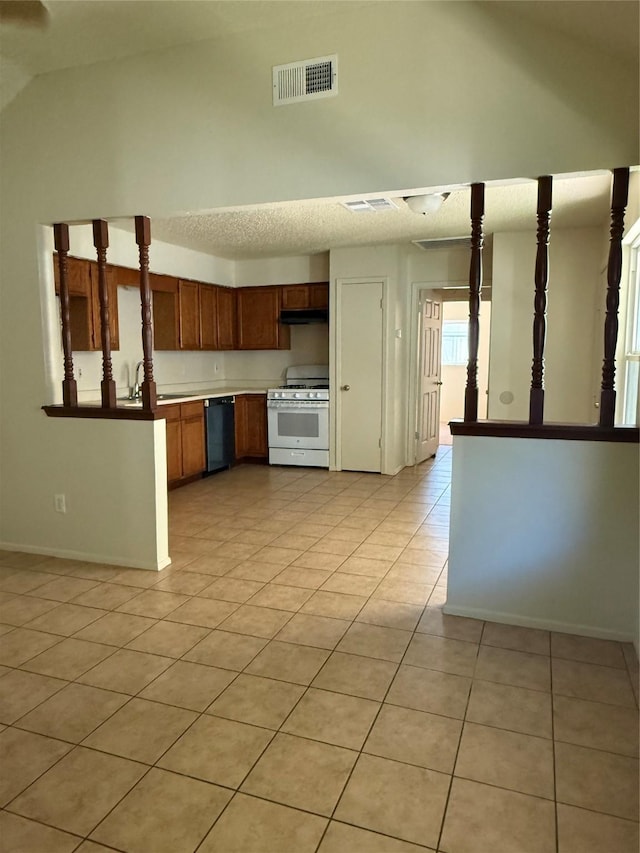 kitchen featuring dishwasher, light tile patterned flooring, and white gas range oven