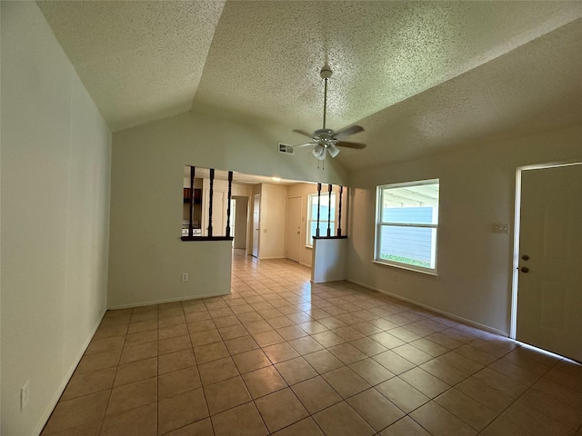 tiled empty room featuring a textured ceiling, ceiling fan, and lofted ceiling