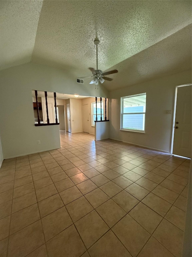 unfurnished living room with ceiling fan, lofted ceiling, a textured ceiling, and light tile patterned floors