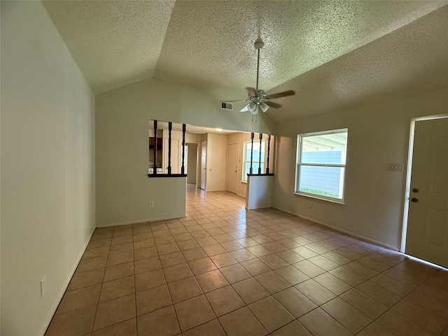 tiled empty room with a textured ceiling, ceiling fan, and vaulted ceiling