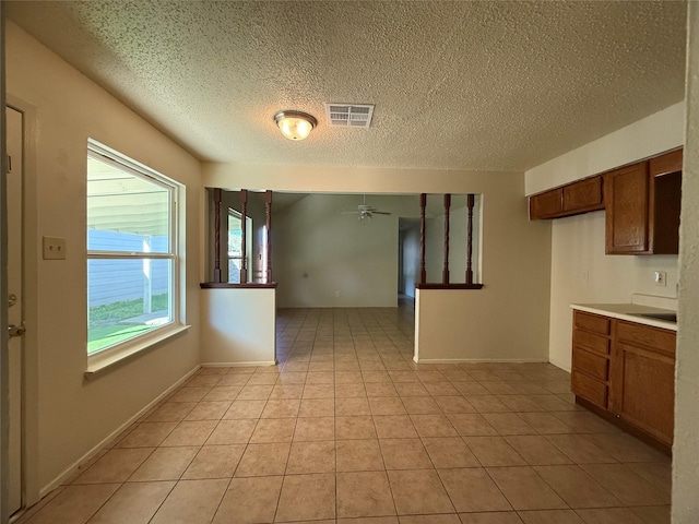 kitchen with ceiling fan, light tile patterned floors, and a textured ceiling