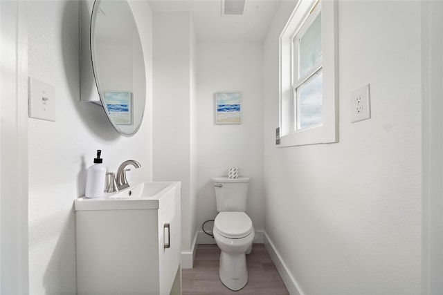 bathroom featuring wood-type flooring, vanity, and toilet