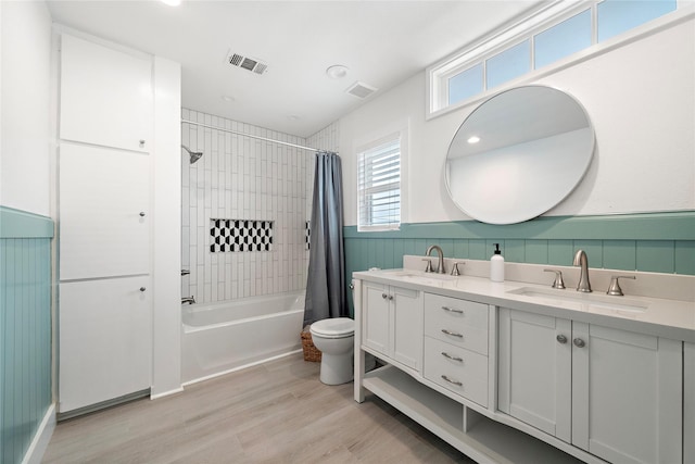 full bathroom featuring hardwood / wood-style flooring, vanity, toilet, and shower / tub combo with curtain