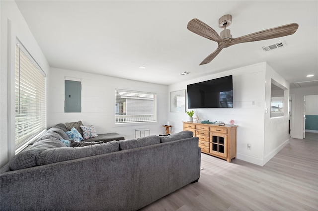 living room with light wood-type flooring, electric panel, and ceiling fan