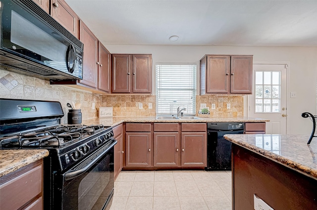 kitchen with light stone countertops, sink, backsplash, and black appliances