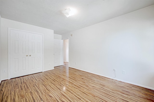 unfurnished bedroom featuring light hardwood / wood-style floors and a closet