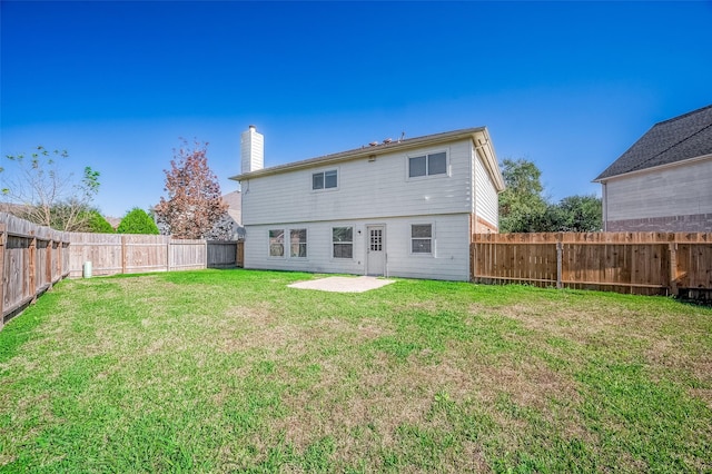 rear view of property featuring a yard and a patio