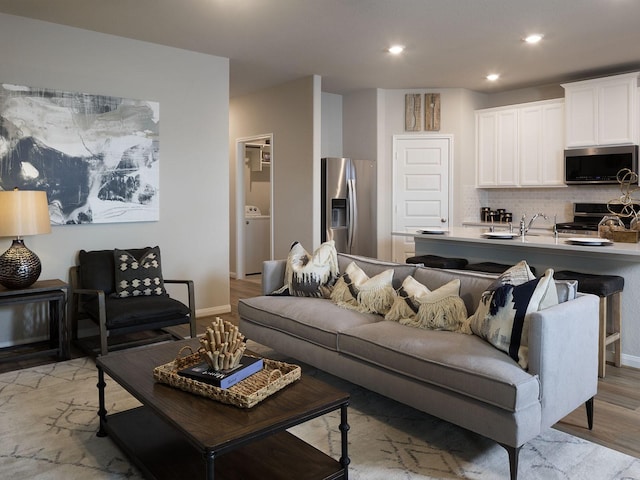 living room with washer / clothes dryer and sink