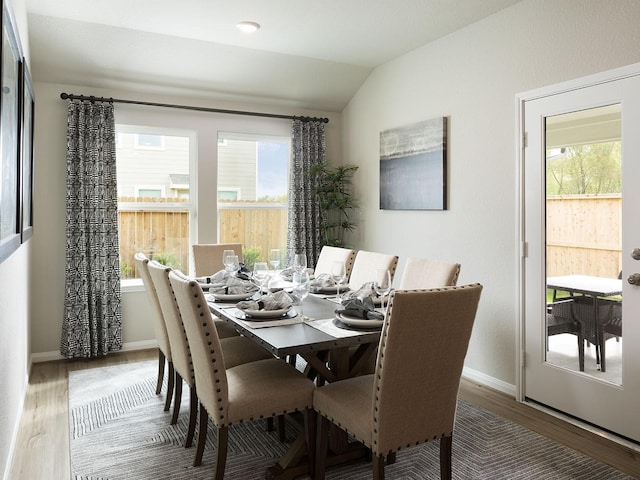 dining area featuring hardwood / wood-style flooring, plenty of natural light, and lofted ceiling