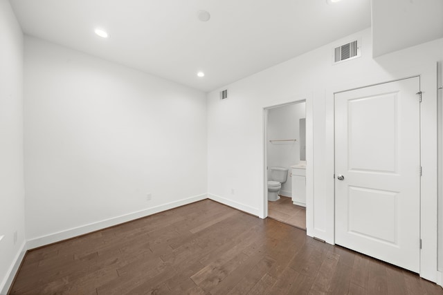 unfurnished bedroom featuring dark hardwood / wood-style floors and ensuite bathroom