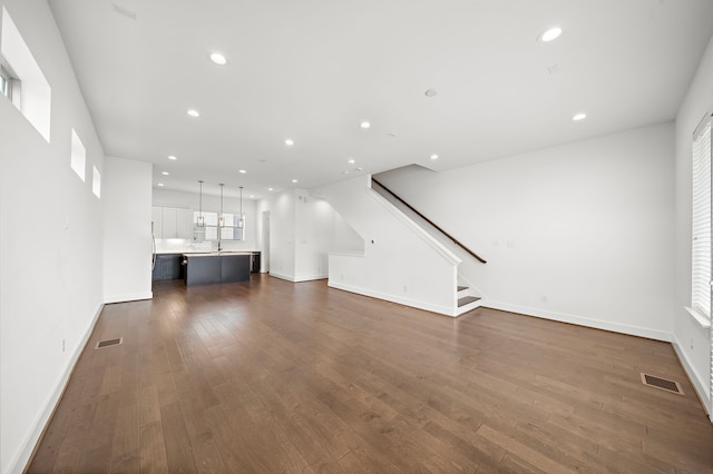 unfurnished living room with sink and dark hardwood / wood-style floors