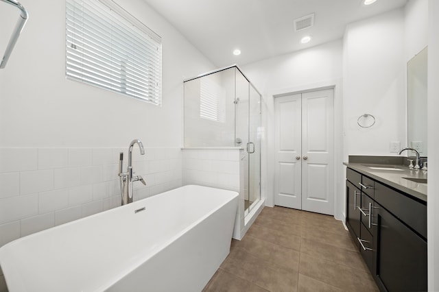 bathroom featuring tile patterned flooring, shower with separate bathtub, and vanity