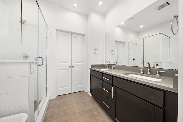 bathroom with tile patterned flooring, vanity, and a shower with door