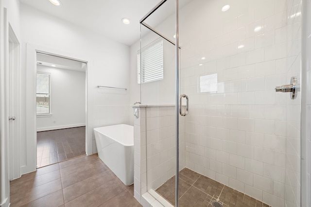 bathroom with tile patterned flooring, plenty of natural light, and separate shower and tub