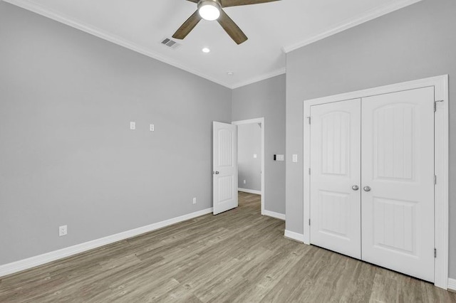 unfurnished bedroom with a closet, ceiling fan, crown molding, and light hardwood / wood-style floors