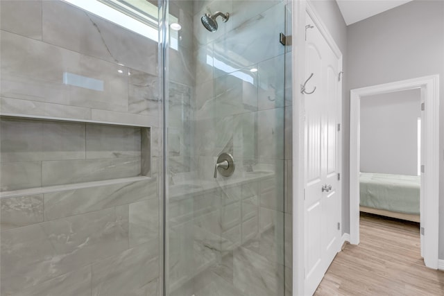 bathroom with hardwood / wood-style floors and a shower with door