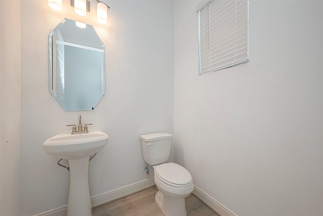 bathroom with hardwood / wood-style floors, toilet, and sink