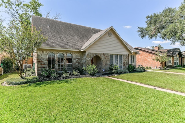 english style home featuring central AC and a front lawn