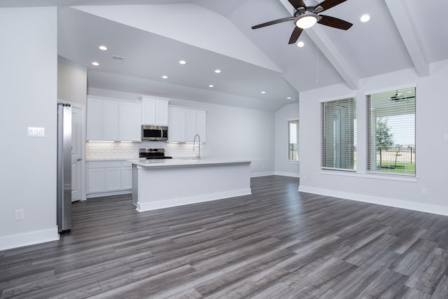 kitchen featuring a kitchen island with sink, vaulted ceiling with beams, dark hardwood / wood-style flooring, white cabinetry, and stainless steel appliances