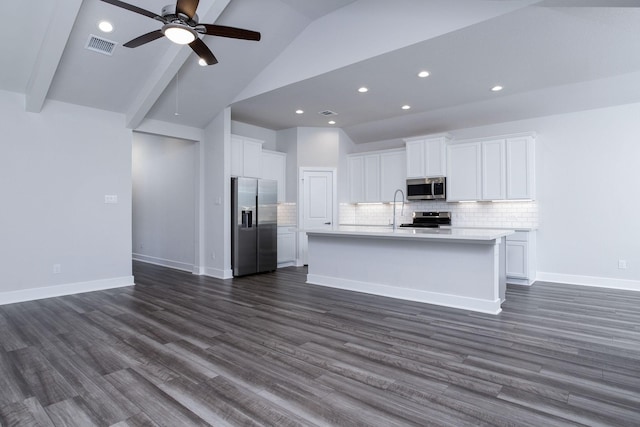 kitchen featuring white cabinetry, dark wood-type flooring, stainless steel appliances, beamed ceiling, and a center island with sink