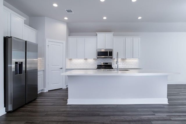 kitchen featuring appliances with stainless steel finishes, a kitchen island with sink, white cabinets, and dark hardwood / wood-style flooring