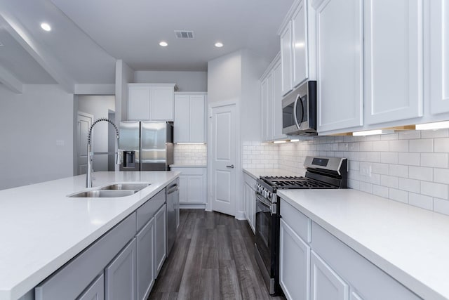 kitchen featuring white cabinetry, sink, dark hardwood / wood-style flooring, and appliances with stainless steel finishes