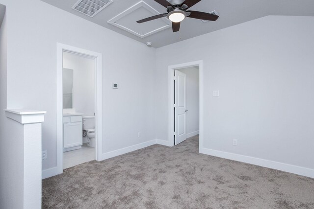 unfurnished bedroom with vaulted ceiling, light colored carpet, ceiling fan, and ensuite bathroom