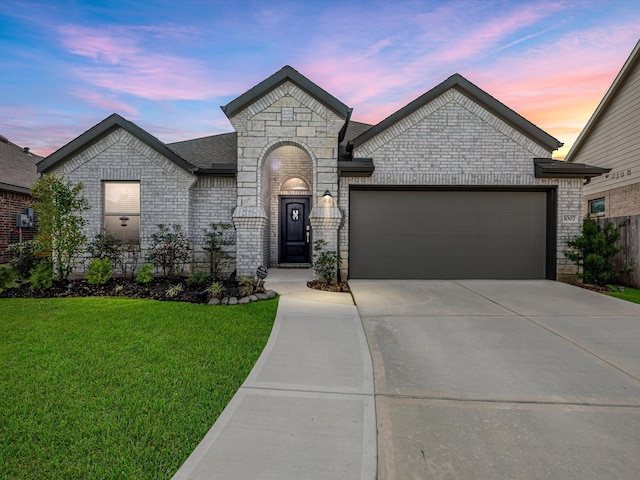 french provincial home featuring a yard and a garage