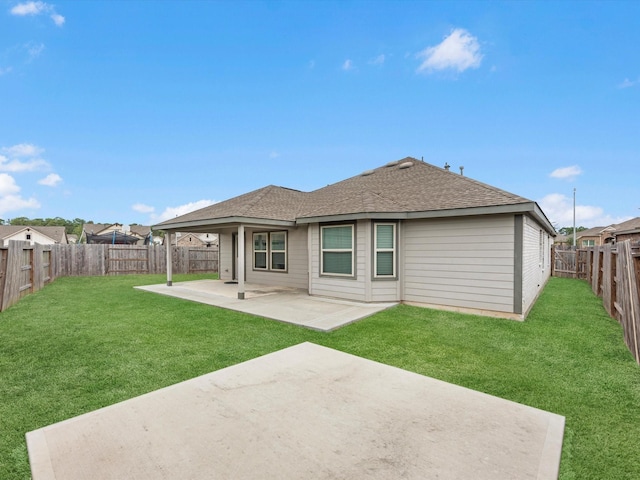 back of house with a yard and a patio