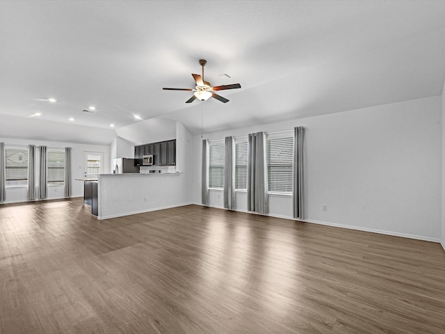 unfurnished living room featuring ceiling fan, dark hardwood / wood-style floors, and vaulted ceiling