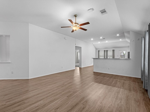 unfurnished living room with hardwood / wood-style flooring, ceiling fan, and vaulted ceiling