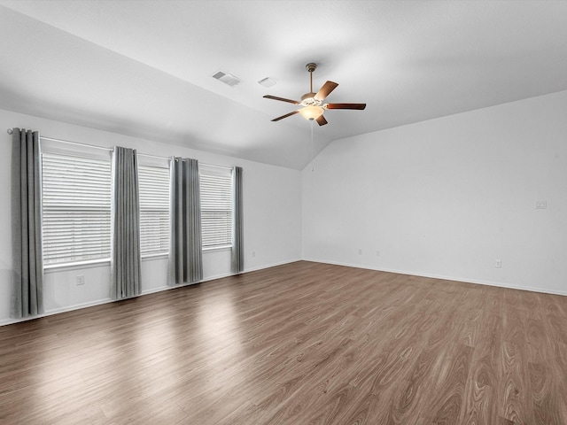 empty room with hardwood / wood-style flooring, ceiling fan, and vaulted ceiling