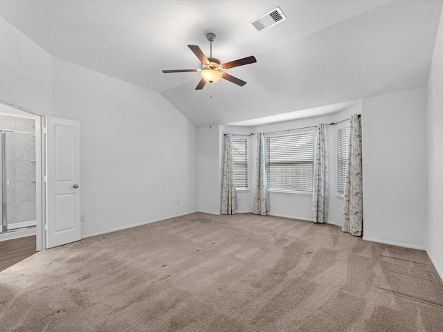 carpeted spare room with vaulted ceiling and ceiling fan