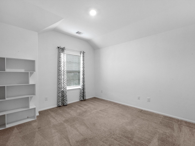 interior space with light carpet and vaulted ceiling