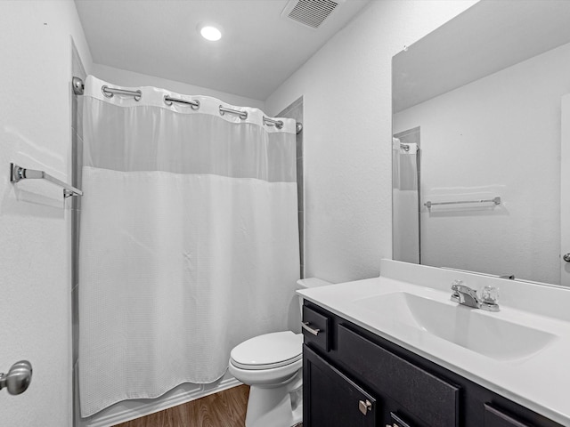 full bathroom featuring vanity, wood-type flooring, shower / tub combo, and toilet