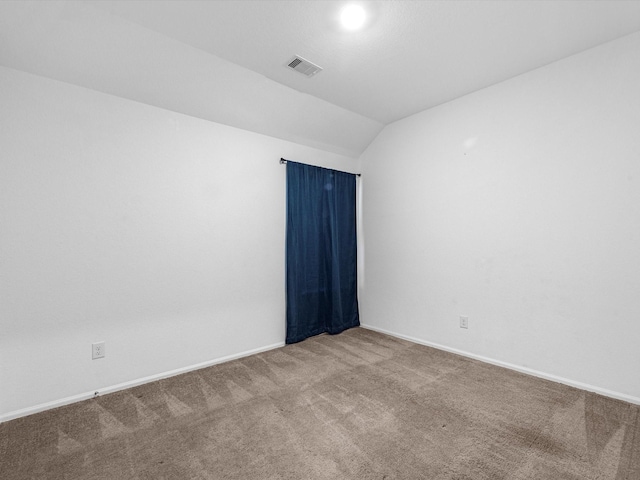 empty room featuring carpet flooring and vaulted ceiling