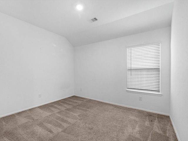 unfurnished room featuring carpet and lofted ceiling