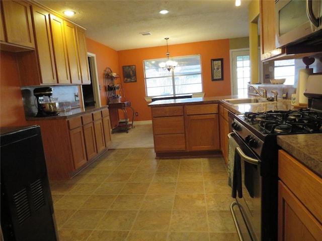 kitchen with sink, a wealth of natural light, decorative light fixtures, stainless steel appliances, and a chandelier