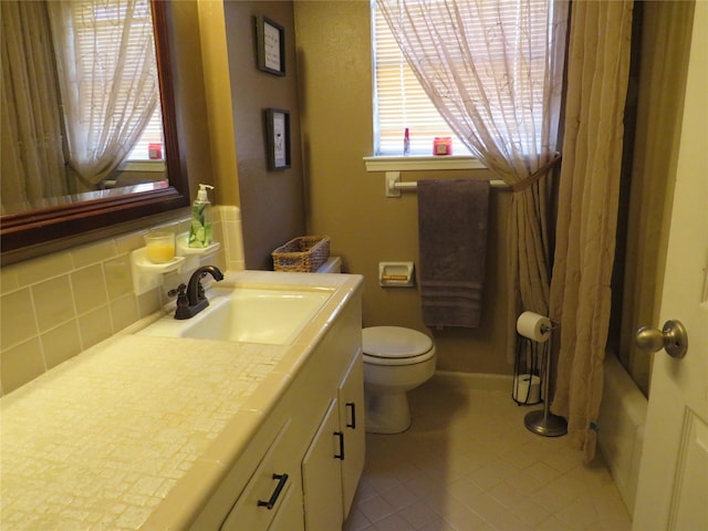 bathroom featuring toilet, tasteful backsplash, tile patterned floors, and a healthy amount of sunlight