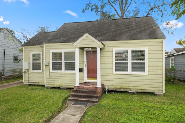 bungalow-style home with a front lawn and central AC unit