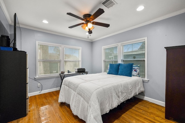 bedroom with ceiling fan, wood-type flooring, and ornamental molding