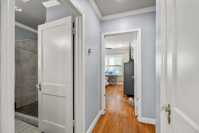 hall with light hardwood / wood-style floors and ornamental molding